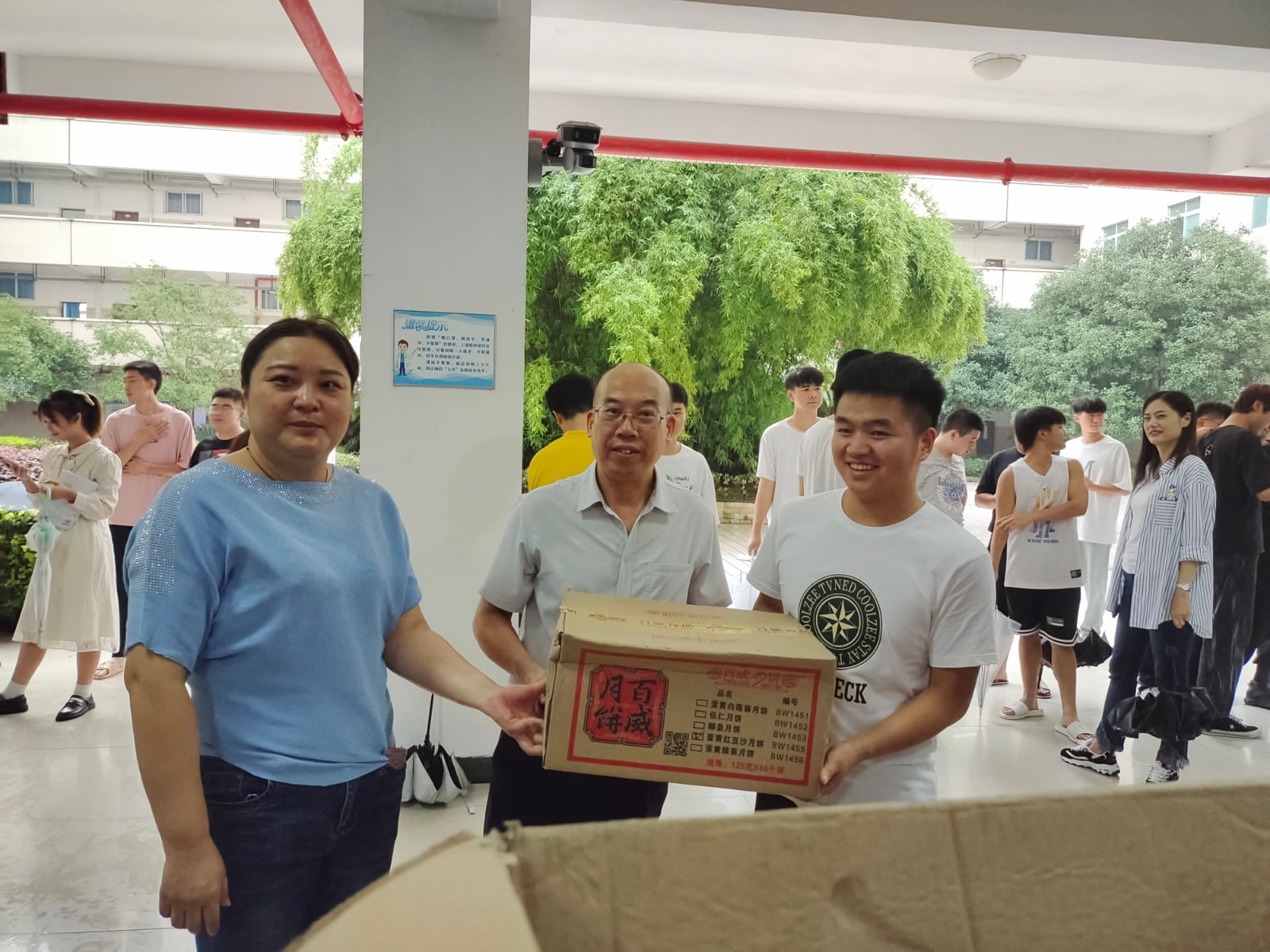 党委委员副校长文斌(中)为学生发月饼.jpg 党委委员副校长文斌(中)为学生发月饼.jpg